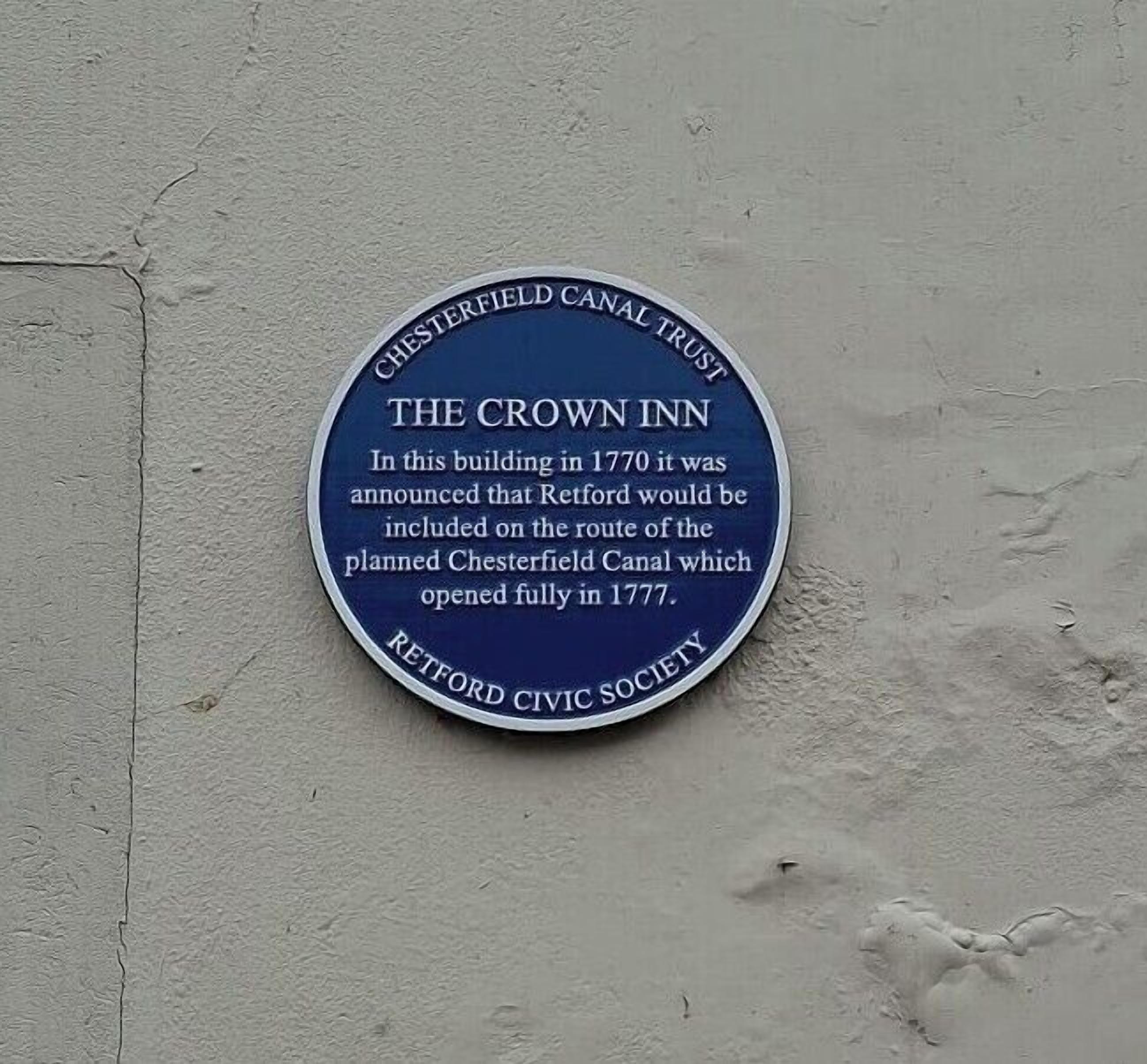 En rund plade med historiske oplysninger om The Crown Inn og Chesterfield Kanal Trust.