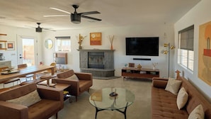 A living room with a fireplace, sofas, a coffee table, and a TV.