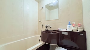 A bathroom with a bathtub, a sink, and toiletries.