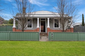 A two-story house with a front porch, a brick base, and a metal roof. - Central Bendigo Charmer, Sleeps 6 (Bendigo)
