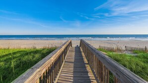 A wooden boardwalk leading to a beach with a clear blue sky. - Oceanfront Penthouse, Pool, Lazy River & Waterpark (North Myrtle Beach)