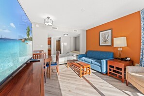 Een hotelkamer met een groot raam, een bank, een bijzettafeltje en een televisie.