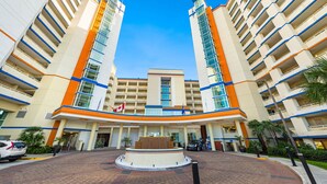 A hotel with a central courtyard, multiple floors, and a flag. - Oceanfront Penthouse, Pool, Lazy River & Waterpark (North Myrtle Beach)