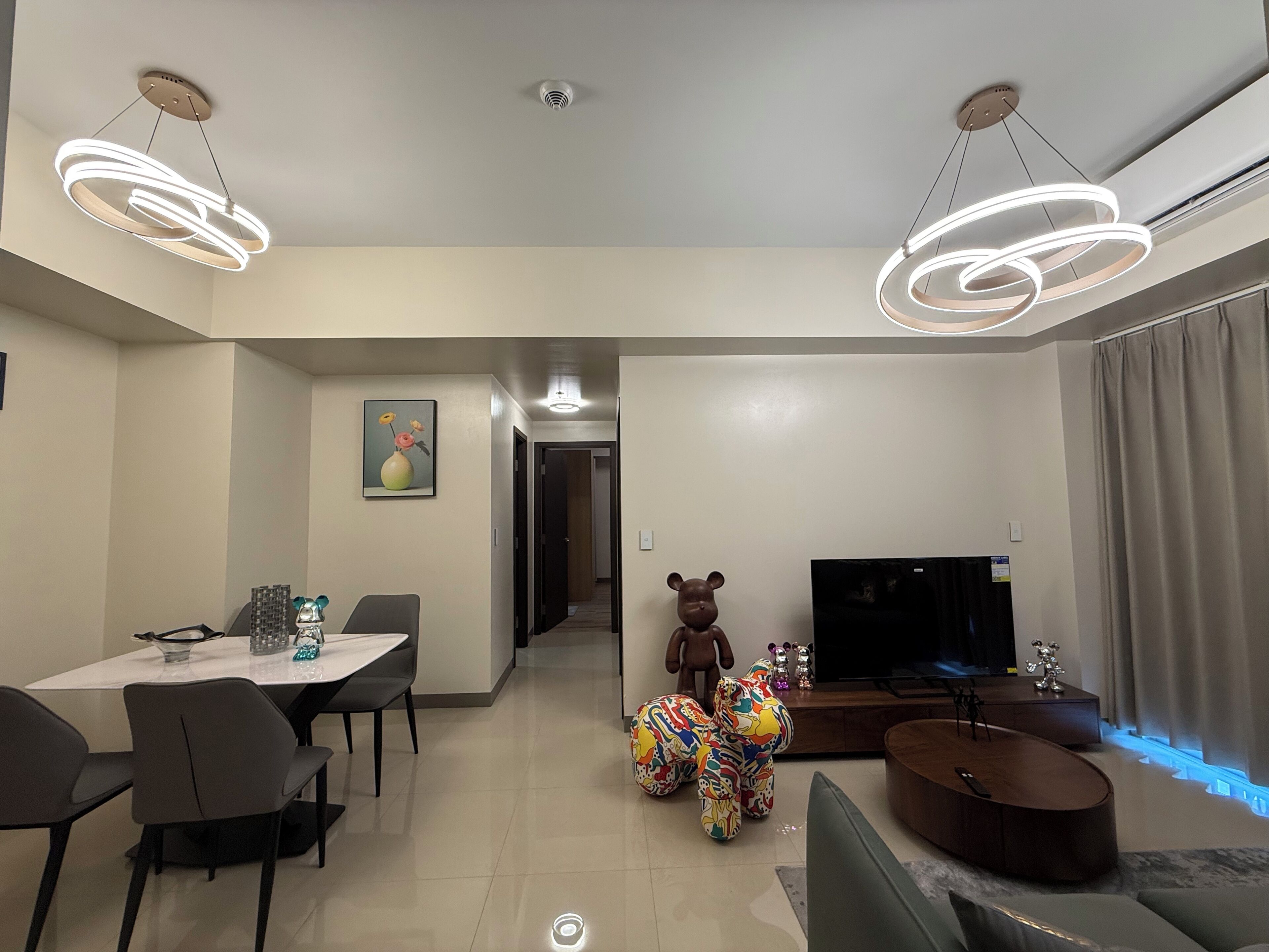 Een moderne woonkamer met een eethoek, een televisie en een bank.