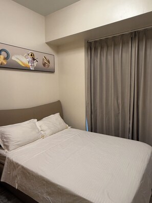 A hotel room with a bed, pillows, a headboard, a window with curtains, and a wall-mounted artwork. - Seaview PoolView Retreat Next Okada NAIA (Parañaque)