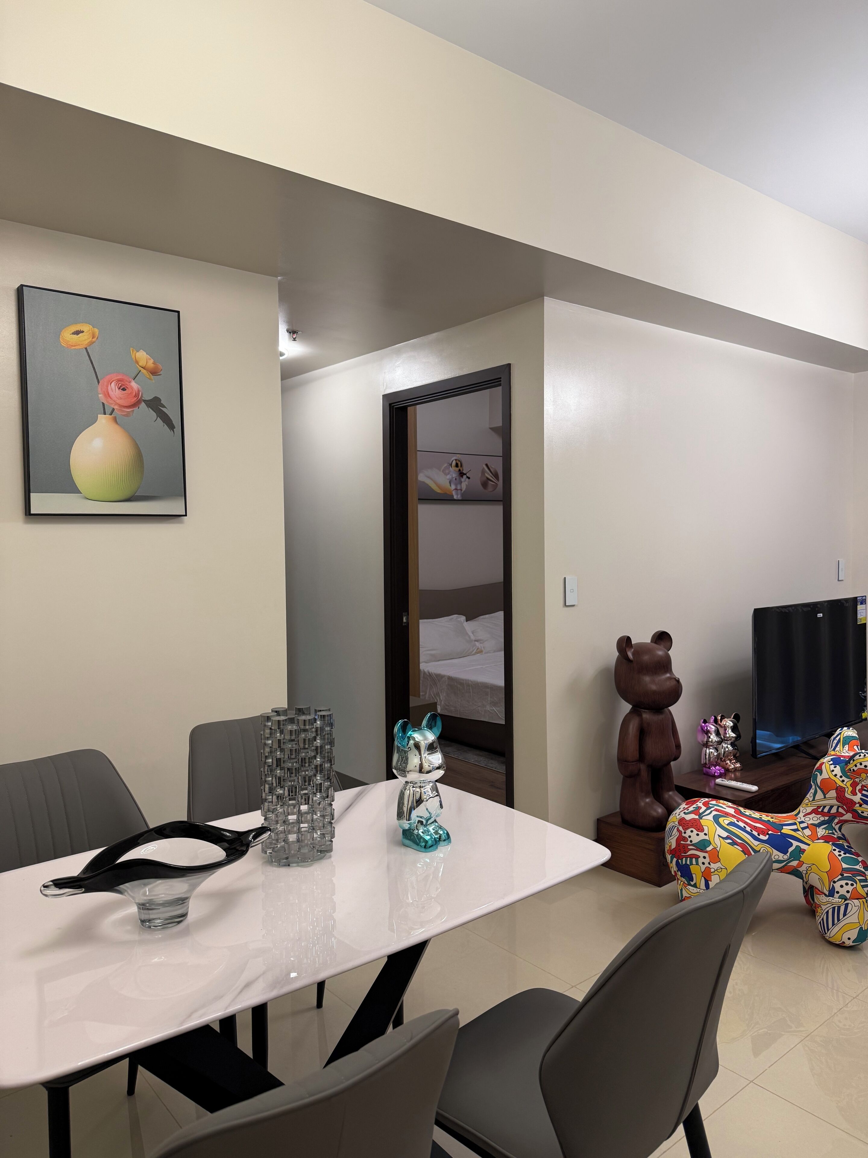 Una sala de estar moderna con una mesa de comedor, sillas, televisor y sofá.