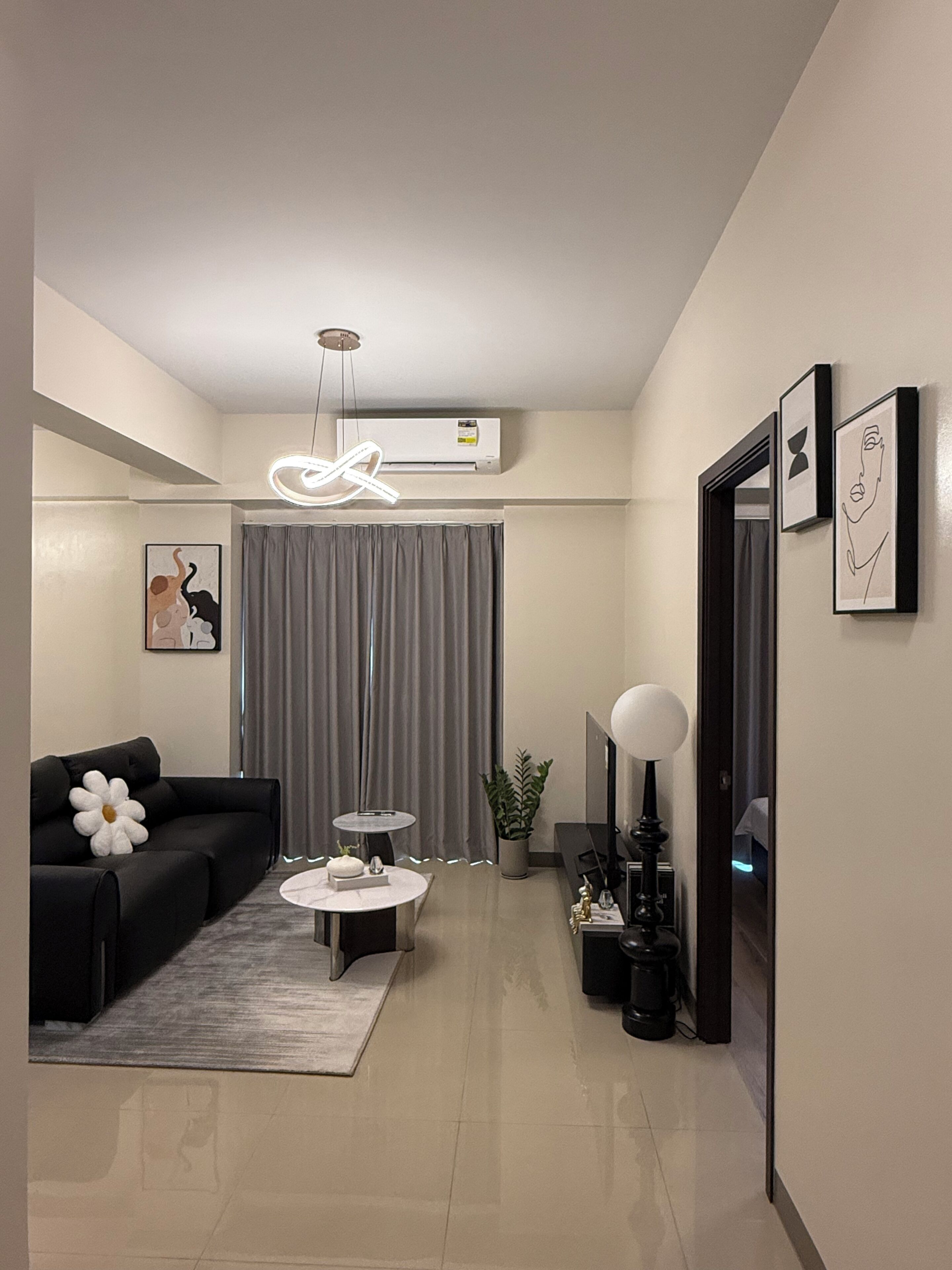 A modern living room with a sofa, coffee table, and a decorative plant.