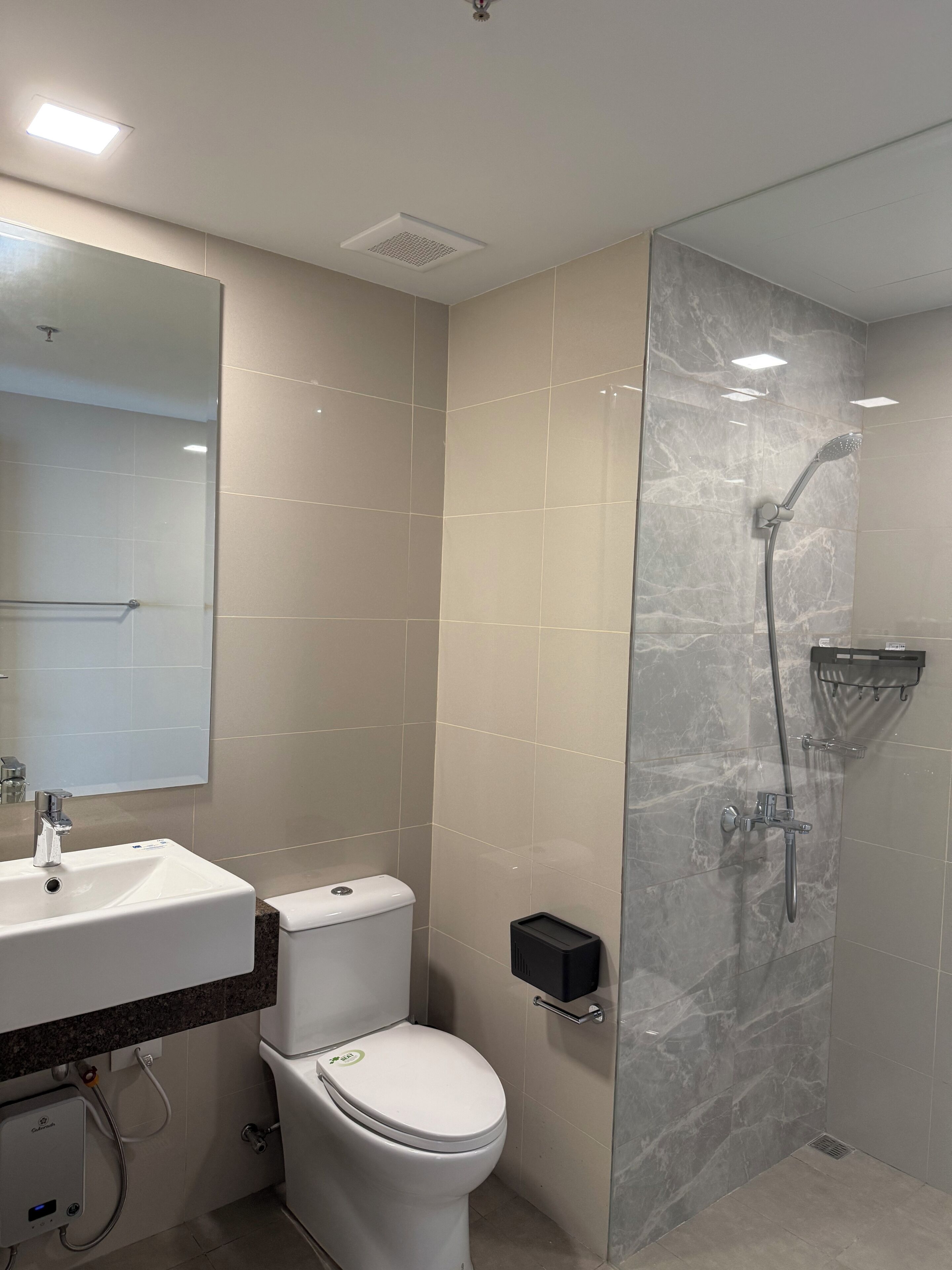 A modern bathroom with a toilet, sink, and shower.