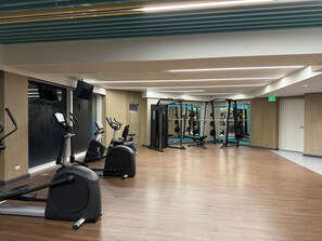 A gym with cardio machines, weightlifting equipment, and a mirror on the wall. - Seaview PoolView Retreat Next Okada NAIA (Parañaque)