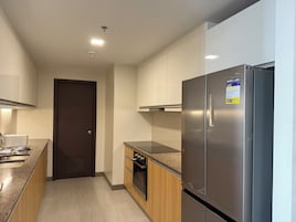 Una cocina moderna con electrodomésticos de acero inoxidable, armarios de madera y horno empotrado.