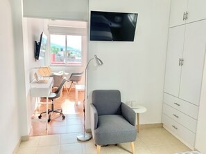 A modern room with a desk, chair, lamp, TV, and wardrobe. - Sky Flat 2_3___600 mbps fibre optic Wifi__ Great mountain views (Oaxaca de Juárez)