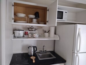 Eine Küche mit Mikrowelle, Wasserkocher und Spüle.