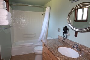 Een badkamer met een bad, toilet en wastafel.