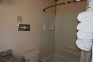 Een badkamer met toilet, douche en een handdoekrek.