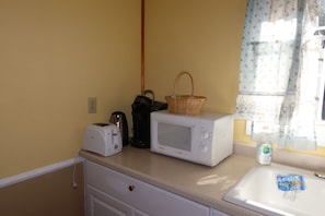 A kitchenette with a toaster, a microwave, and a basket on the counter. - 2 Queen Beds, 1 Sofa Bed, Kitchen, Fireplace (Packwood)