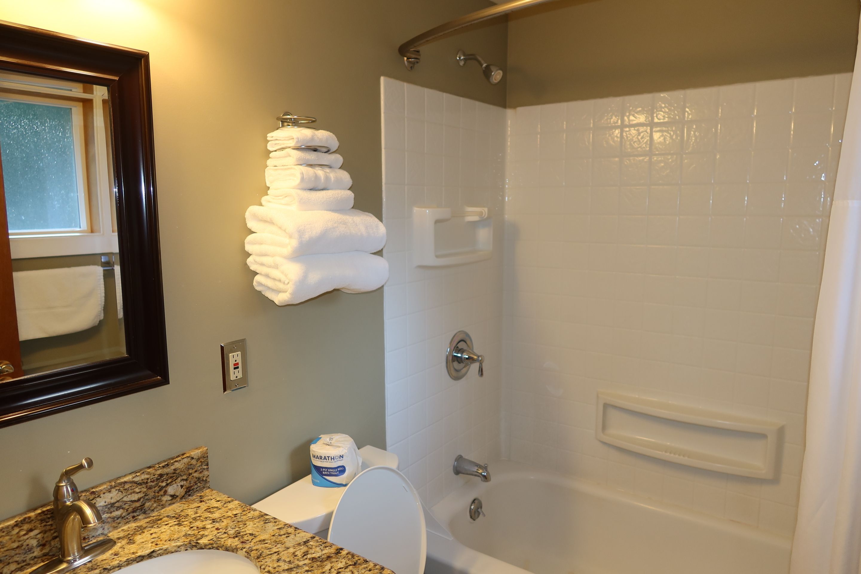 A bathroom with a sink, toilet, and shower.