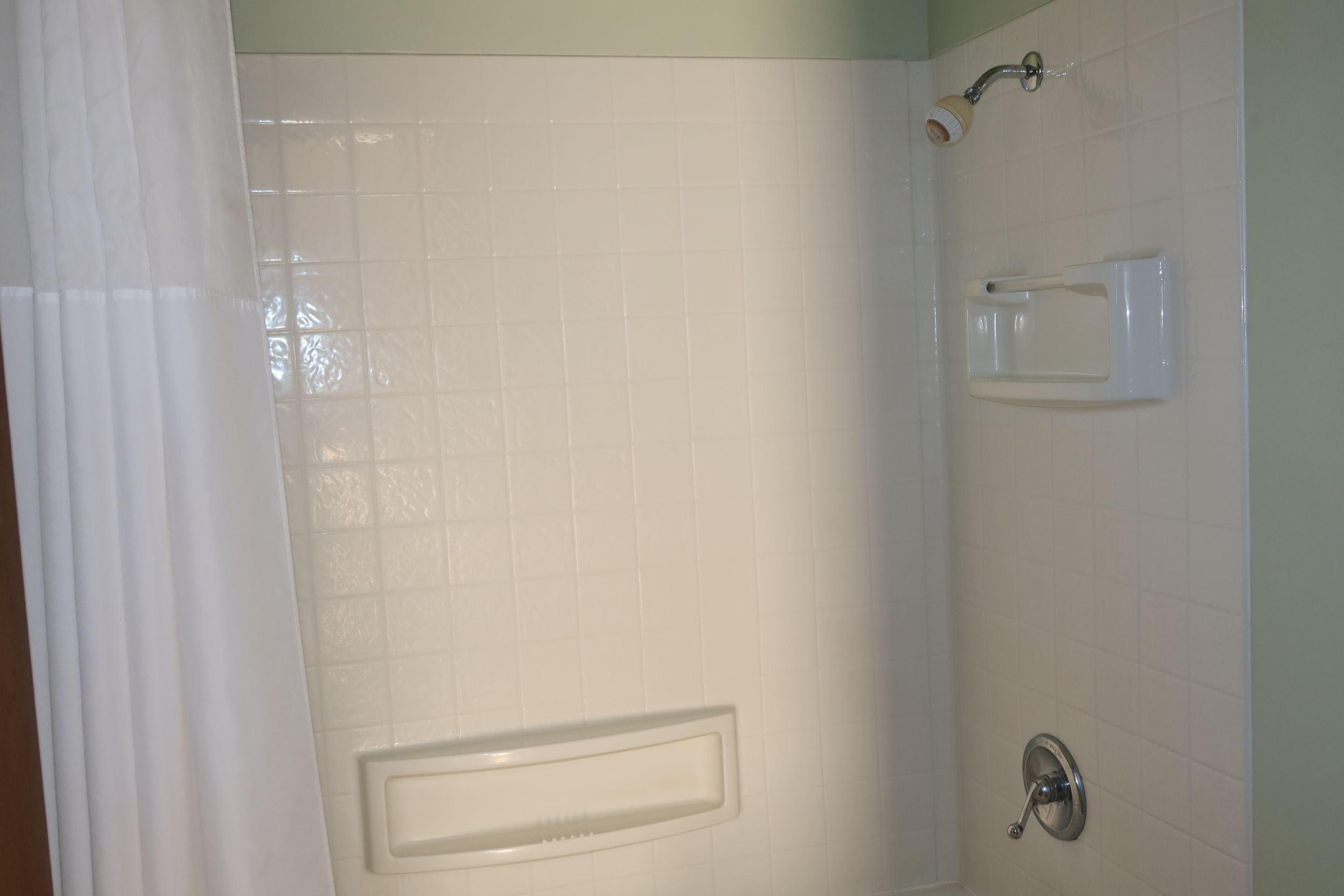 Een badkamer met een douche, toilet en wastafel.