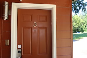 A brown door with the number 3, a doorbell, and a 'No Entry' sign.