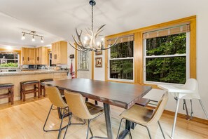 Une cuisine moderne dotée d’un grand îlot central, de meubles en bois et d’un coin repas avec des chaises.