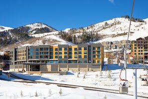 A modern hotel with a ski lift in the background. - Canyon Haus 326 | Modern Studio | Mountain View | Heated Pool | Hot Tub | WiFi (Park City)