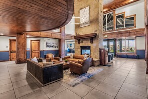 A spacious lobby with a fireplace, leather sofas, and a large stone wall. - Silverado 126 | Mountain View | Patio | Pool | Short Walk to Lift (Park City)