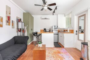 A compact living space with a kitchenette, a ceiling fan, and a dining area.