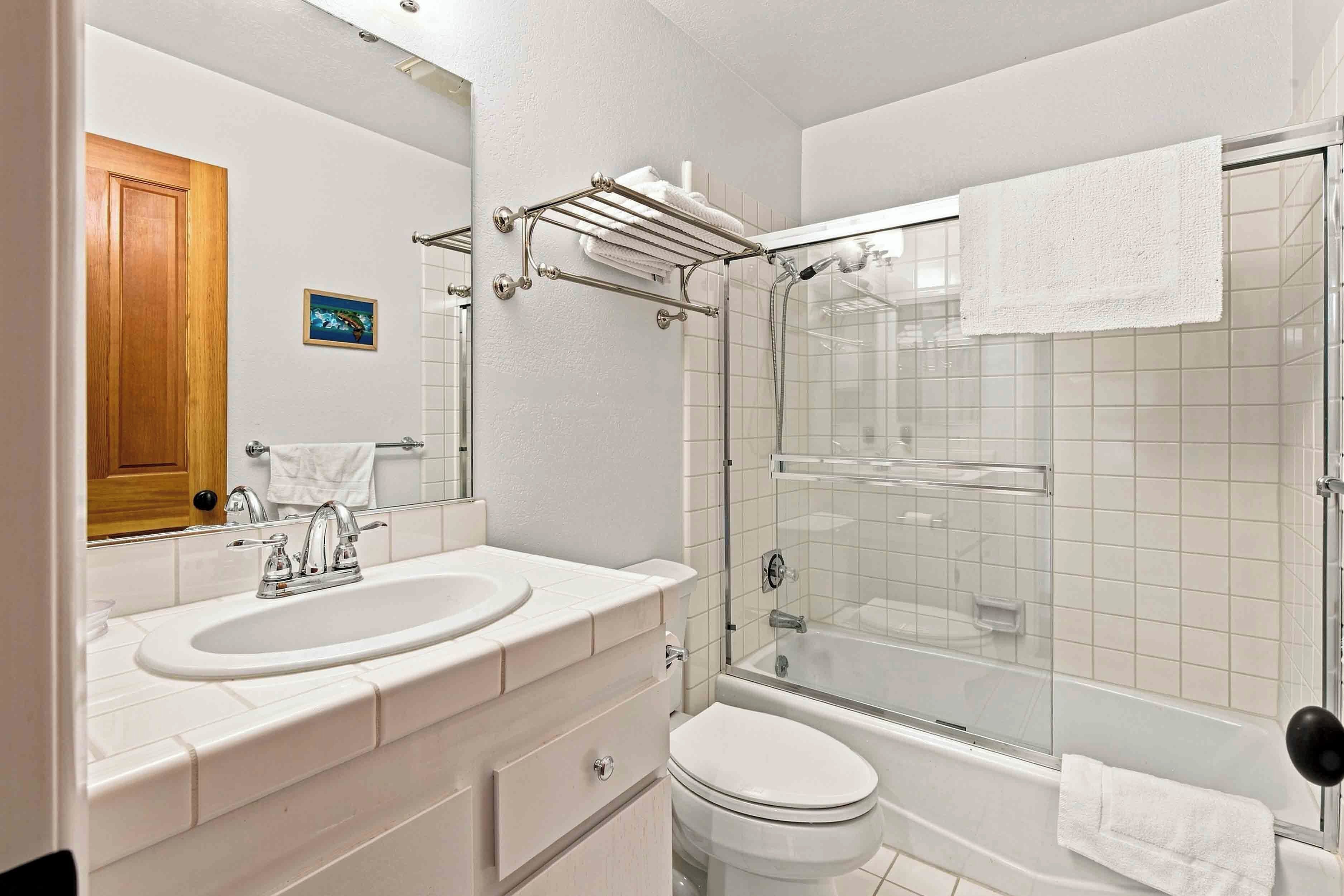 Une salle de bain avec deux éviers, des toilettes et une douche à parois de verre.