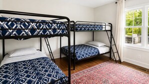 A room with bunk beds, a window with curtains, and a patterned rug. - Home in Union Pier, MI (Union Pier)