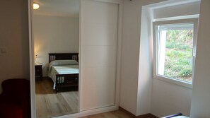 A bedroom with a bed, a window, and a sliding door leading to another room. - Casa Lago-Marí — Large house near the sea (Lariño)