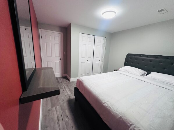 Un dormitorio con cama, armario y espejo.