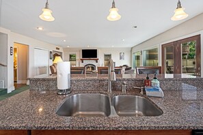 A kitchen with granite countertops, stainless steel sinks, and a built-in oven.