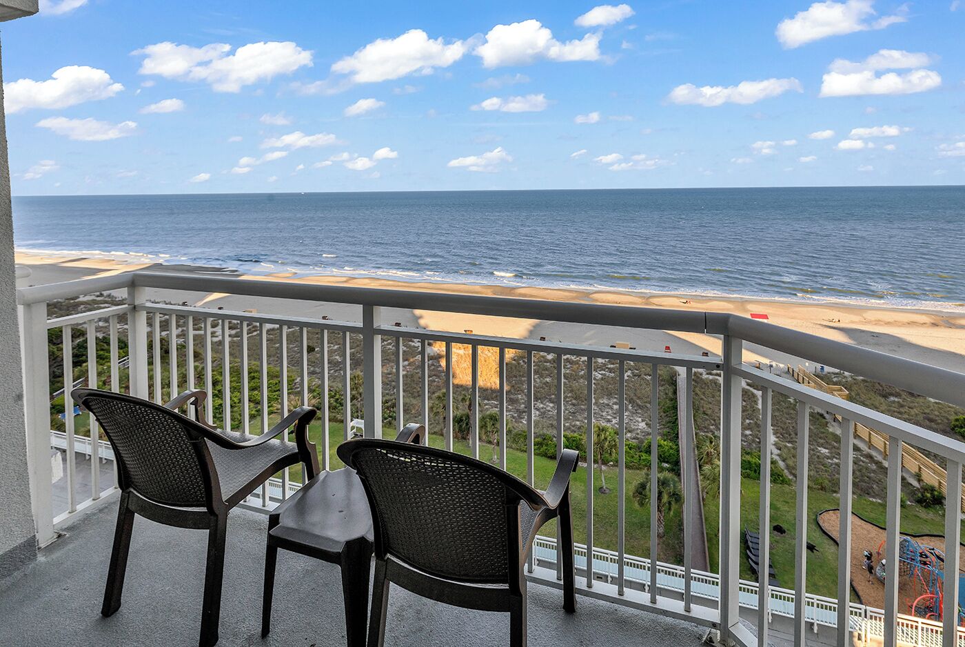A balcony with a view of the ocean and beach.
