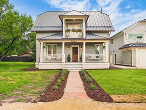 A two-story house with a front porch, a garage, and a well-maintained lawn. - Historic Manor w/ Hidden Speakeasy, 3BR/2.5BA (Heber City)