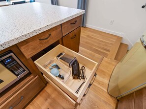 A compact kitchen with a countertop, wooden cabinets, and a built-in microwave. - Swanky Mid Century Gem, 2BR/1BA, Deck, Fireplace (Heber City)