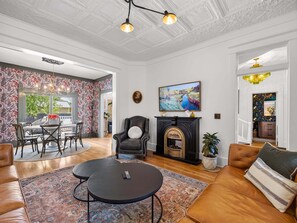Een woonkamer met een open haard, een eethoek en uitzicht op de omgeving.