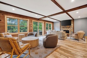Un amplio espacio habitable con chimenea, ventanas grandes y una zona de estar acogedora.