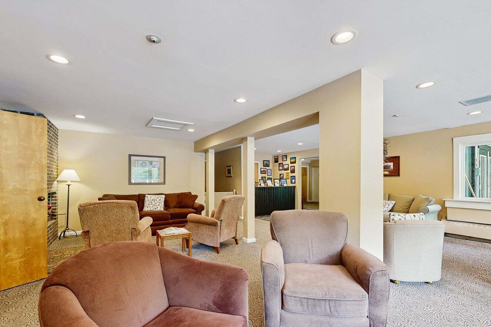 A hotel lobby with seating, a reception desk, and framed pictures on the walls.