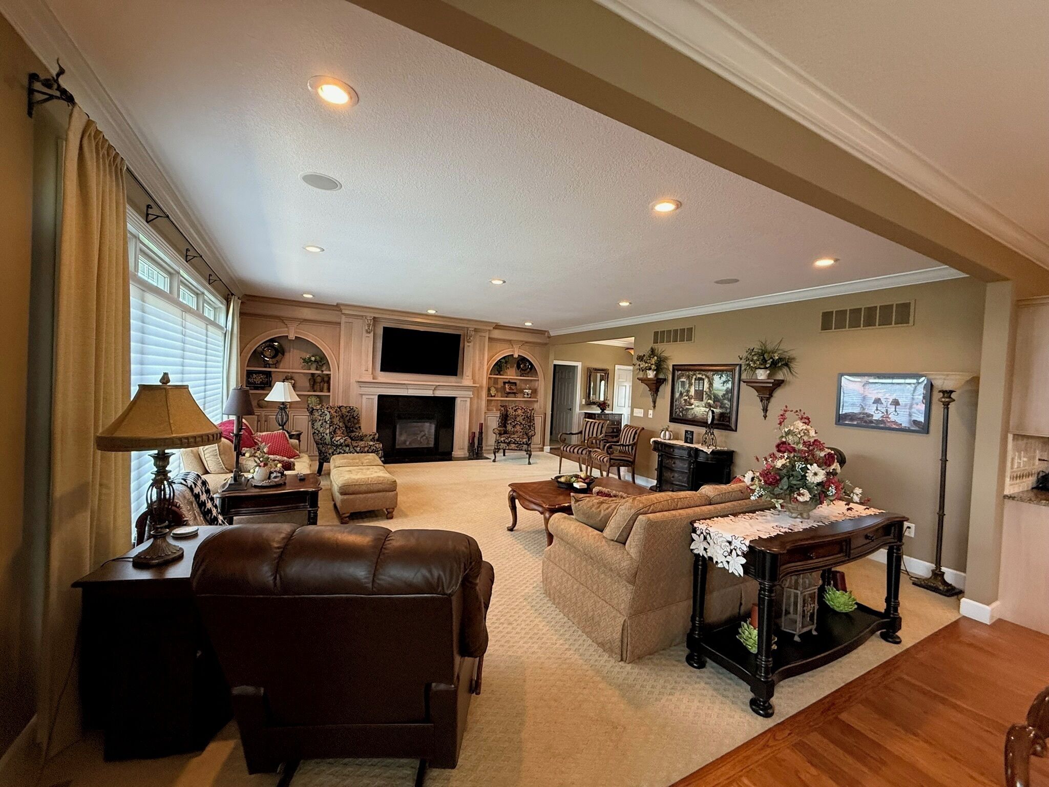 A spacious living room with a fireplace, comfortable seating, and a television.