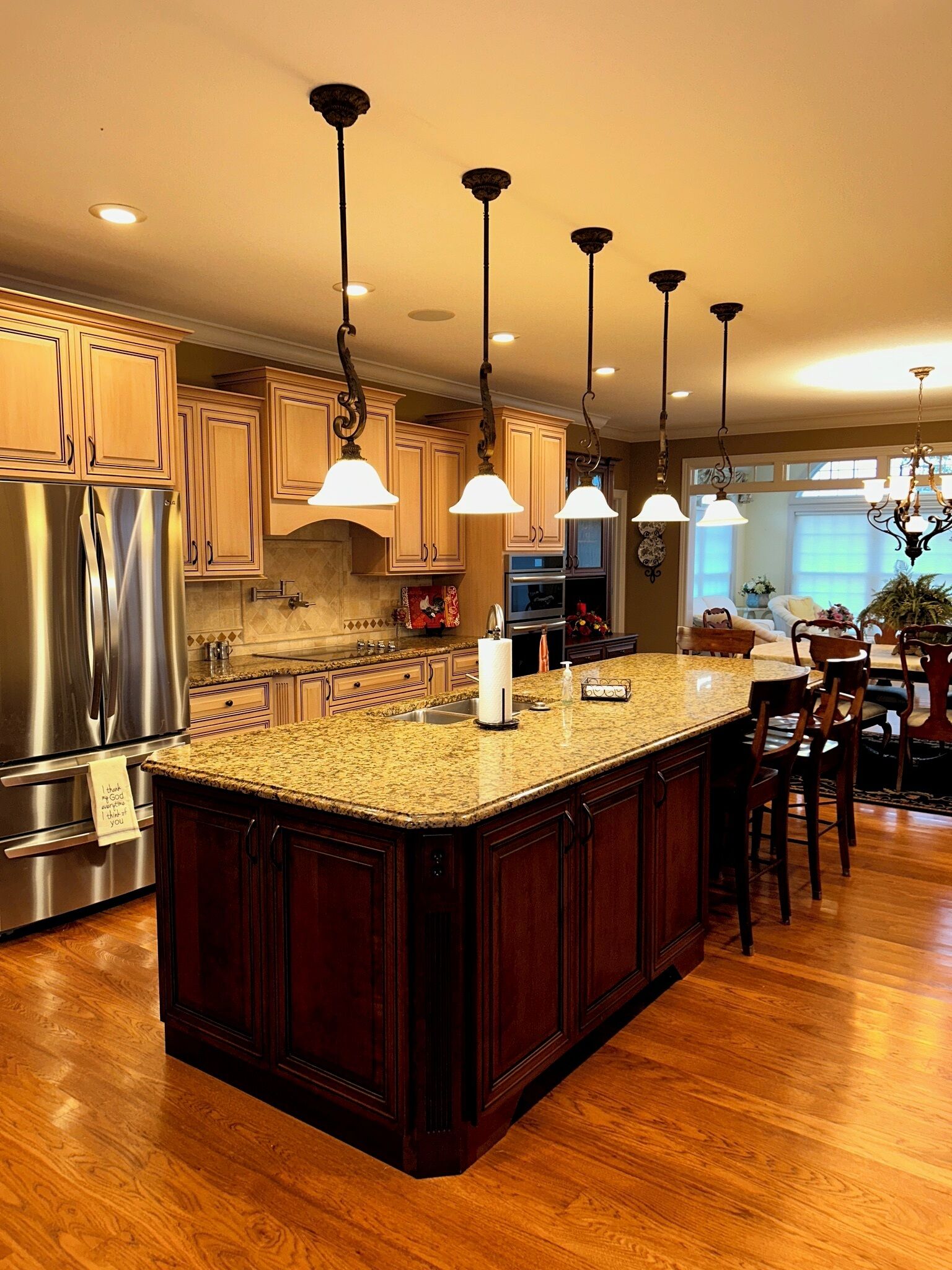 A kitchen with a central island, stainless steel appliances, and pendant lighting.
