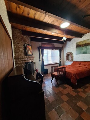 A room with a wooden ceiling, a fireplace, a bed, and a dining table with chairs. - Live in a historic castle near U of A in sunny Tucson (Tucson)