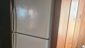 A white refrigerator with a freezer compartment, located in a room with wooden paneling and a tiled floor. - Live in a historic castle near U of A in sunny Tucson (Tucson)