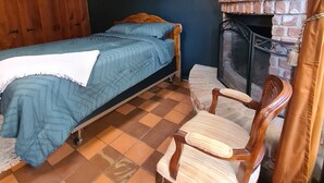 A room with a bed, a chair, a fireplace, and a painting on the wall. - Live in a historic castle near U of A in sunny Tucson (Tucson)
