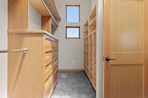 Un dressing avec des étagères en bois et une porte.