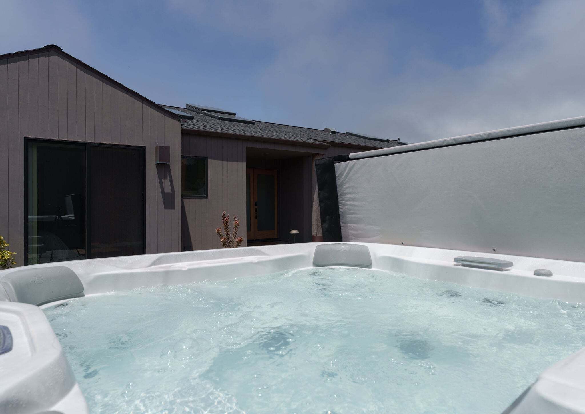 A hot tub with a view of a building in the background.