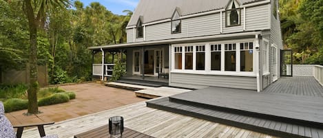 A two-story house with a covered porch and a wooden deck.