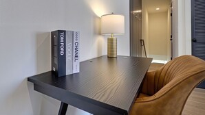 A modern room with a dark wooden table, a lamp, and two books on the table. - Upscale Stay, Free Parking, Walk to Eats and Parks (Birmingham)