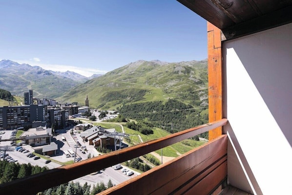 A balcony with a view of a town and mountains.