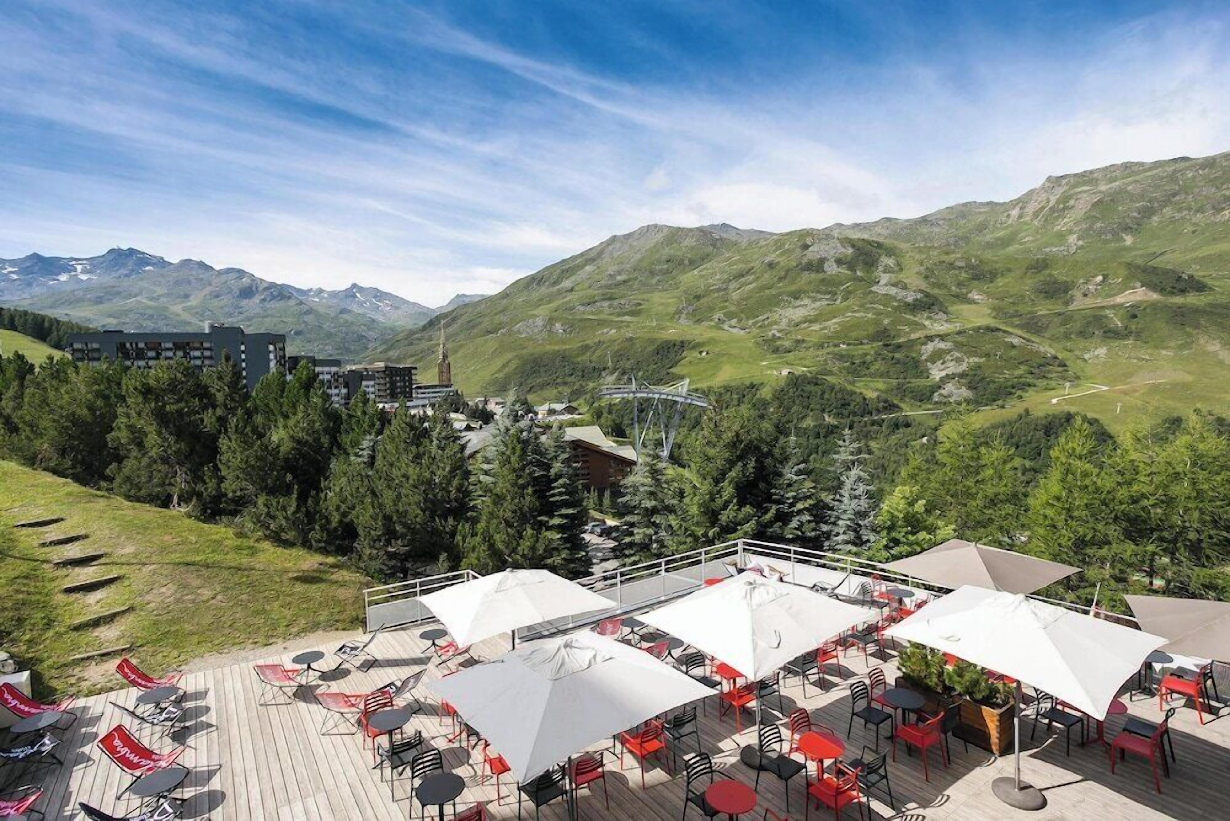 Una terraza con asientos exteriores y vista a la montaña.