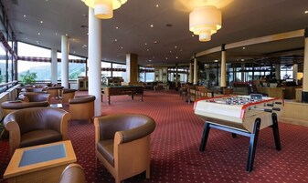 Un vestíbulo de hotel con mesa de billar, mesa de fútbol de mesa y zonas de estar cómodas.