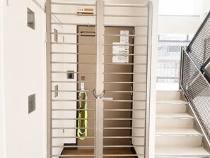 A hotel room with a metal gate, a staircase, and a door with a number sign. - SERENE | Nishikujo, 4th Floor | 60 ㎡, Sleeps 7 | Direct Access to USJ and Osaka Station (大阪市)
